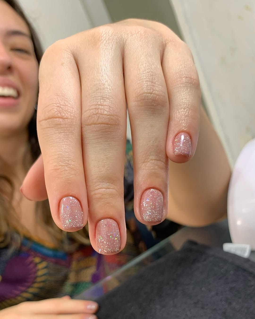 Manicure com esmalte nude e glitter sutil